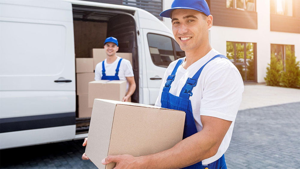 Calgary Movers ABPro movers carrying a moving box beside a moving van in Tuscany, Northwest Calgary
