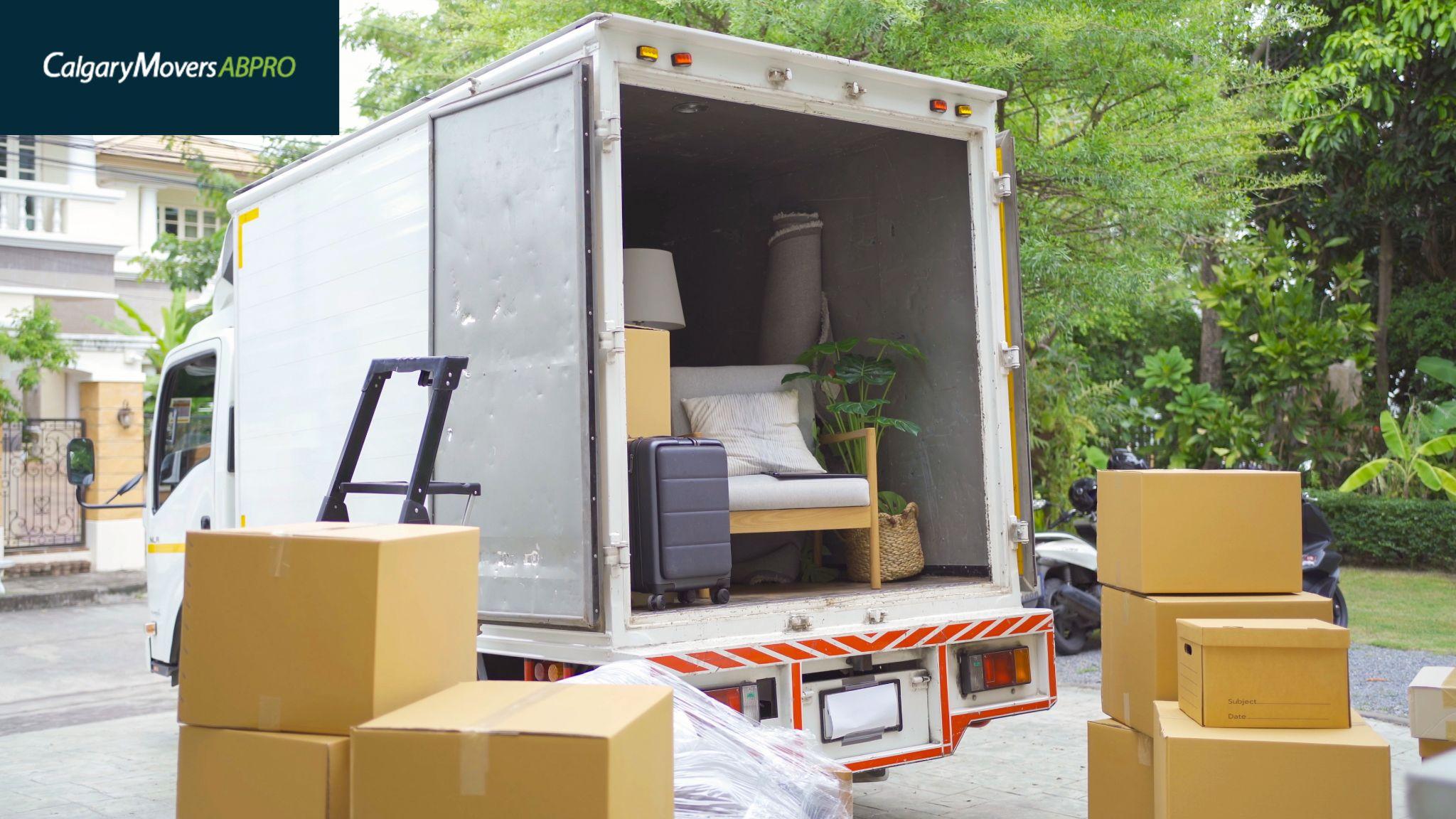 Moving truck loaded with furniture and boxes, parked outside a residential home surrounded by greenery, showcasing a smooth moving process in Calgary