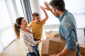 family unpacking boxes together after moving into a new home