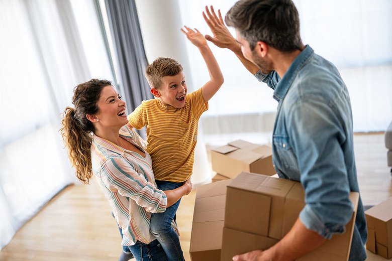 family unpacking boxes together after moving into a new home